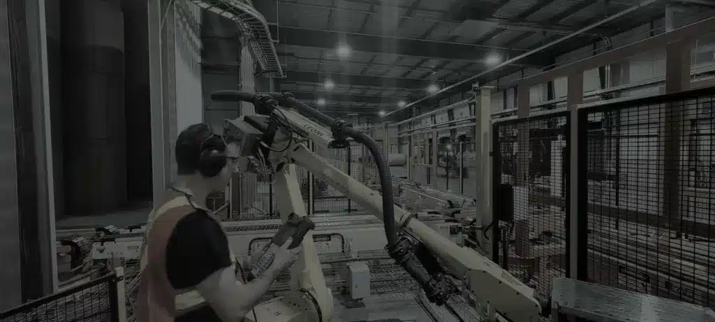 Technician inspecting a production line equipped with industrial robots